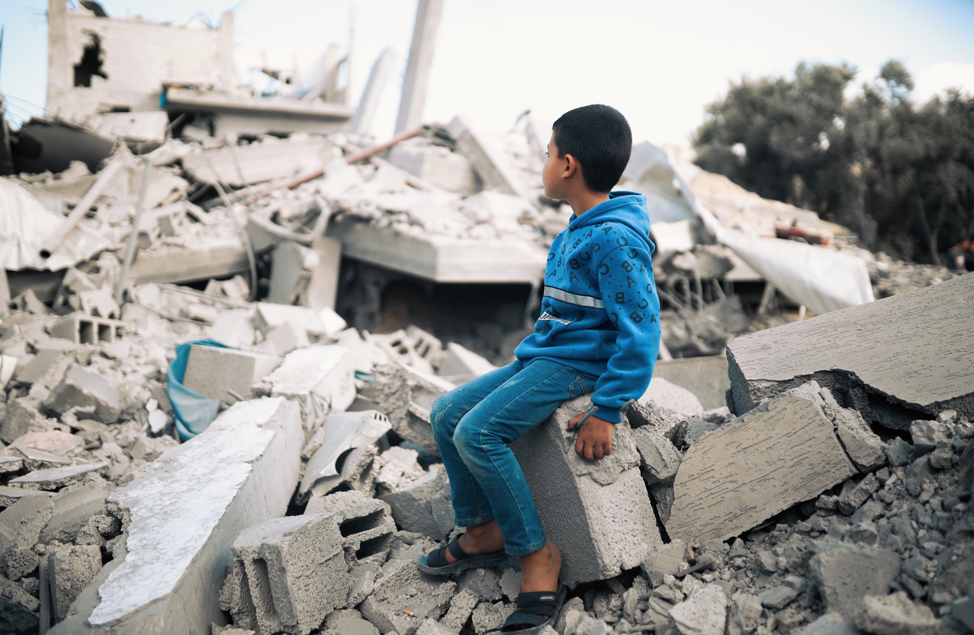 gutt sitter i ruiner av bygning